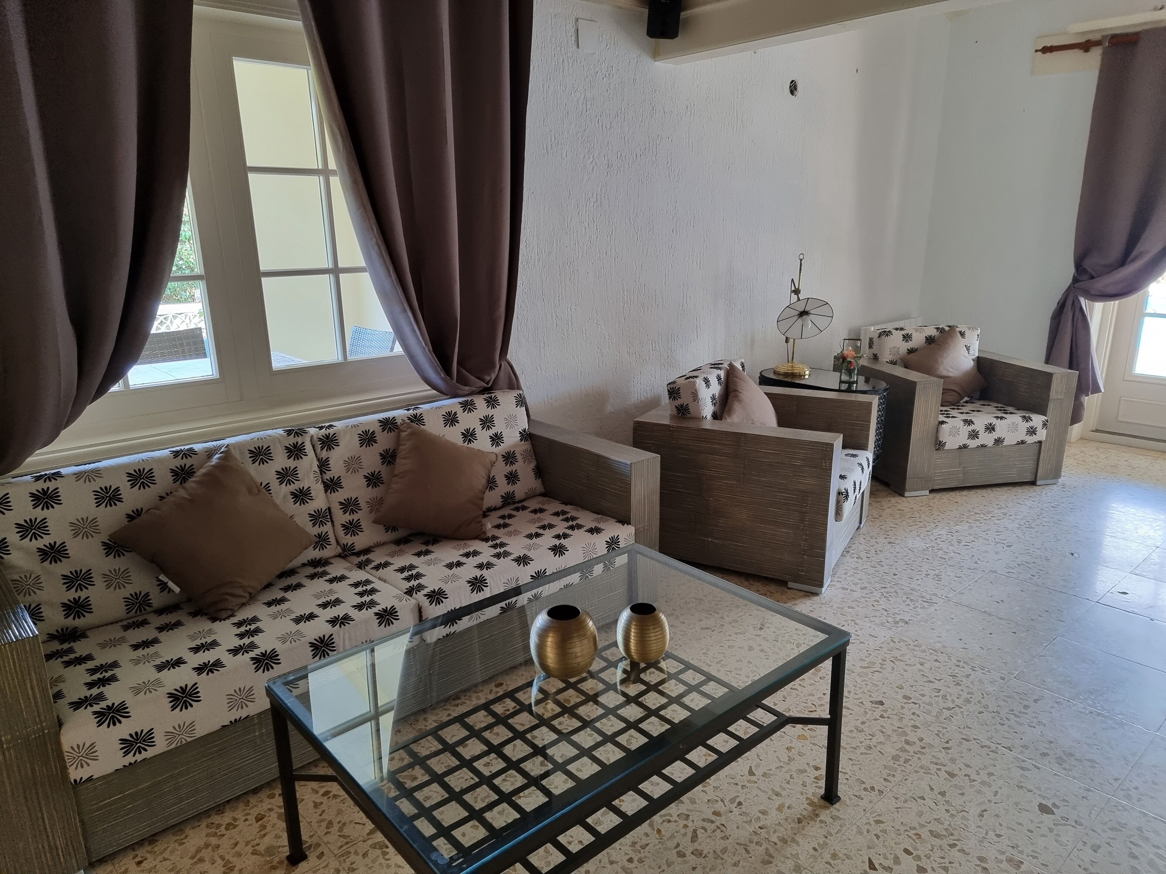 Ein Wohnzimmer mit einer Couch, Sesseln und einem Couchtisch.