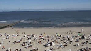 Une plage avec de nombreuses cabanes de plage et un poste de surveillance pour les sauveteurs.