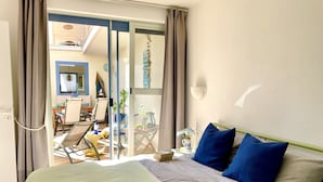 Une chambre d’hôtel avec un lit, une chaise, une table et vue sur le balcon extérieur.