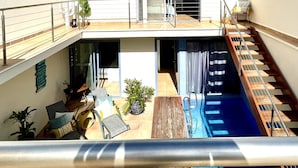 Un bâtiment à deux étages doté d’un balcon, d’une piscine et d’un escalier.