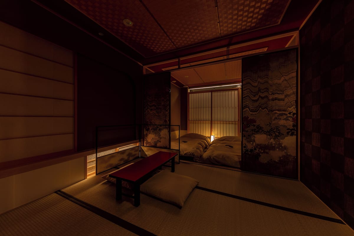 A traditional Japanese room with tatami flooring, a low wooden table, and sliding shoji doors.