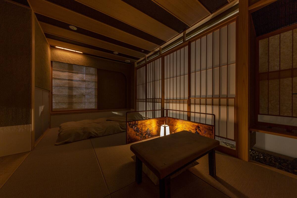 A traditional Japanese room with tatami flooring, a low wooden table, and sliding shoji doors.