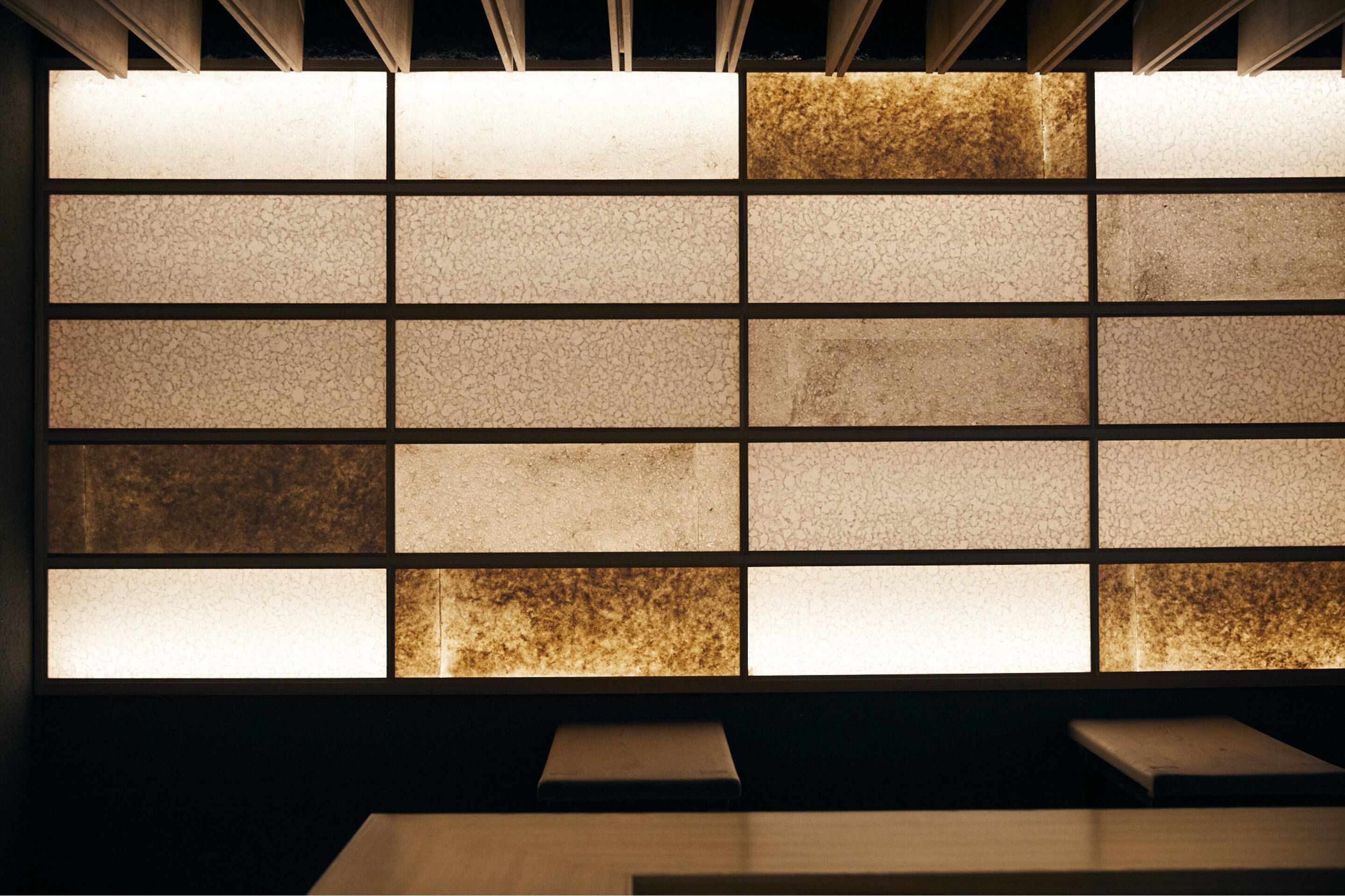 Una pared con una cuadrícula de paneles cuadrados, algunos iluminados.