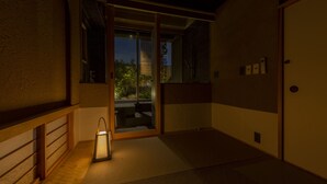 Una habitación japonesa tradicional con suelo de tatami, puertas correderas y un farol.