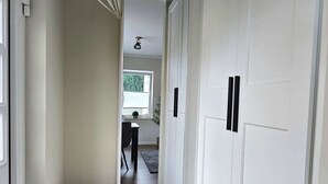 A hallway with wooden flooring, white walls, and a door with black handles. - ***Apartment Saffenburg for 2 persons in the heart of the Ahr valley. (Rech)