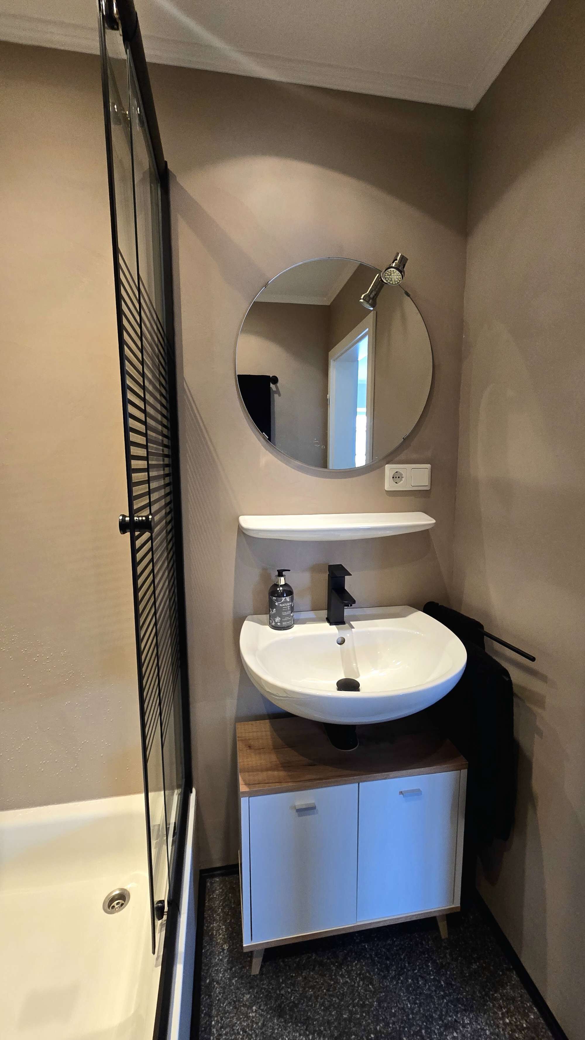 Un baño con bañera, un lavabo con espejo arriba y un mueble debajo.