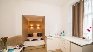 Appartement | Privékitchenette | Een koelkast, een waterkoker, kookgerei, borden en bestek