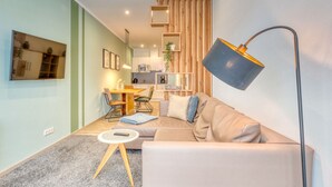 Una sala moderna con un sofá, una mesa de centro y un comedor con sillas.