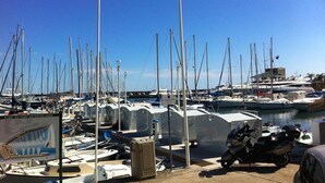 A marina with numerous boats docked, a signboard, and a scooter parked near the water. - Studio, quiet, charming, in the heart of the old town just steps from everything (Antibes)