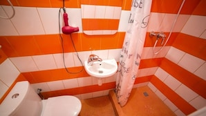 A bathroom with a white toilet, a sink, and a shower area. - Smart Apartment Rappoporta 7a-1 (Lviv)