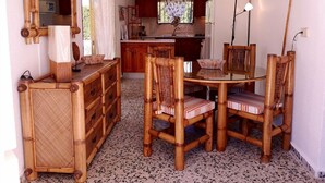A dining area with a round table and four chairs, a wooden cabinet, a mirror, and a ceiling fan. - 2 FULL VILLAS SPECIAL EVENTS 400M SAN GINÈS BEACH - 26 PEOPLE. (Cartagena)