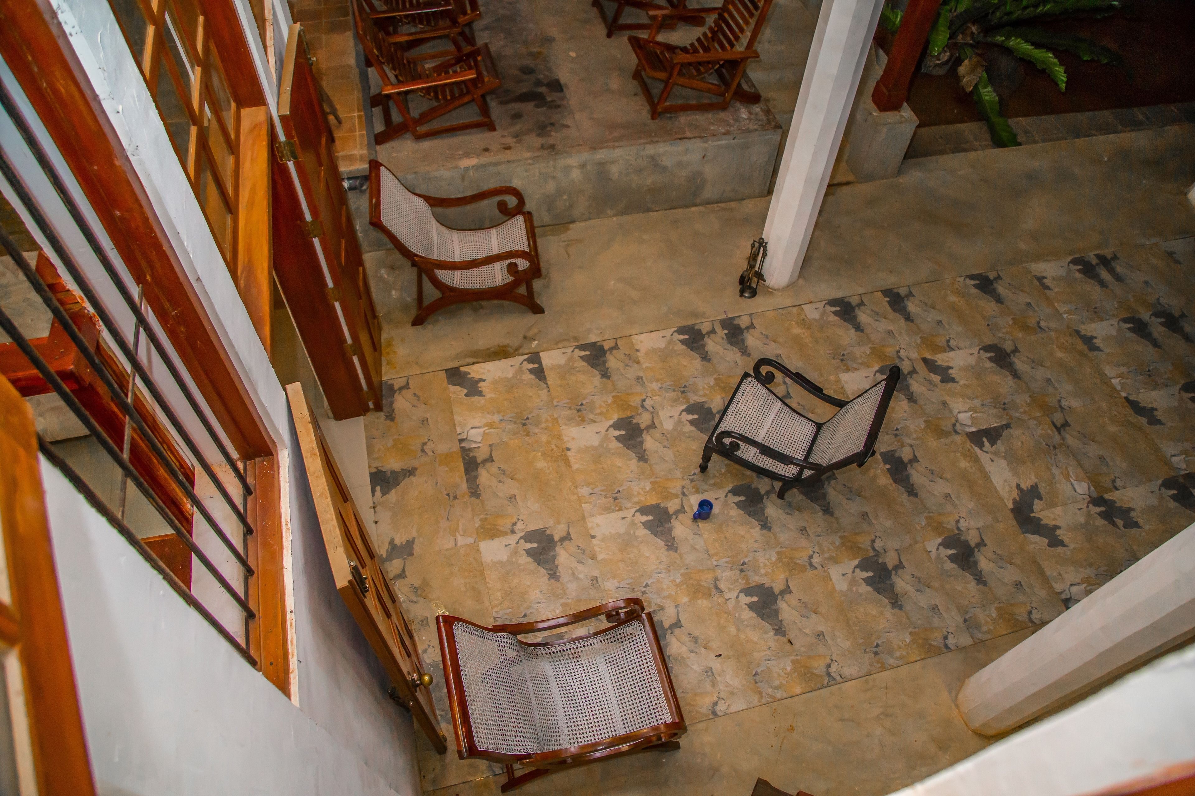 A spacious indoor area with multiple wooden chairs and a tiled floor.