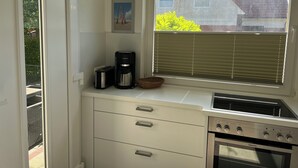A compact kitchen with a built-in oven, a coffee maker, and a toaster. - Maike - Apartment with terrace and small garden (Wangerooge)