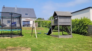 A backyard with a trampoline, a playhouse, and a covered play area. - House in Crozon between the village and the beaches. (Crozon)