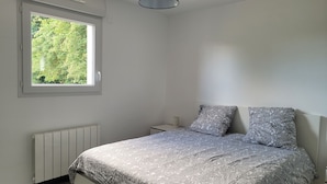 A bedroom with a bed, a window, a radiator, and a ceiling light. - House in Crozon between the village and the beaches. (Crozon)