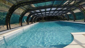 Una piscina interior con techo de cristal y diseño curvo.