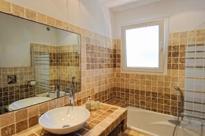 Bathtub, hair dryer, towels, toilet paper