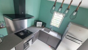 A compact kitchen with a stove, oven, microwave, sink, and refrigerator. - Banan'appart - the magnificent Hermitage T3 with fully renovated garden (L'Ermitage-Les-Bains)