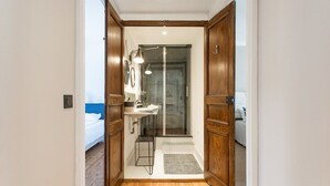 A narrow hallway leading to a bathroom with a sink, mirror, and shower. - Biarritz / Clemenceau / plage & centre ville (Biarritz)