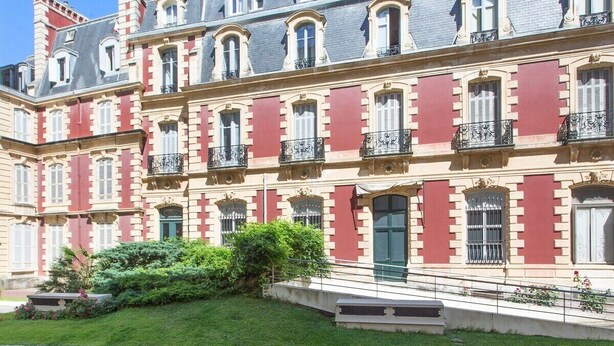 A multi-story building with a classic architectural style, featuring symmetrical windows and a central entrance with a green door. - Biarritz / Clemenceau / plage & centre ville (Biarritz)