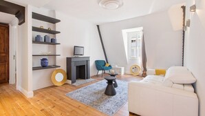 A modern living room with a fireplace, a sofa, and a TV. - Biarritz / Clemenceau / plage & centre ville (Biarritz)