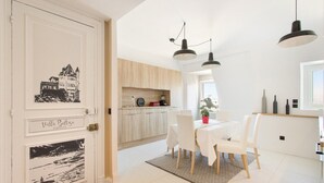A modern kitchen with a wooden countertop and a dining area with white chairs and a table. - Biarritz / Clemenceau / plage & centre ville (Biarritz)