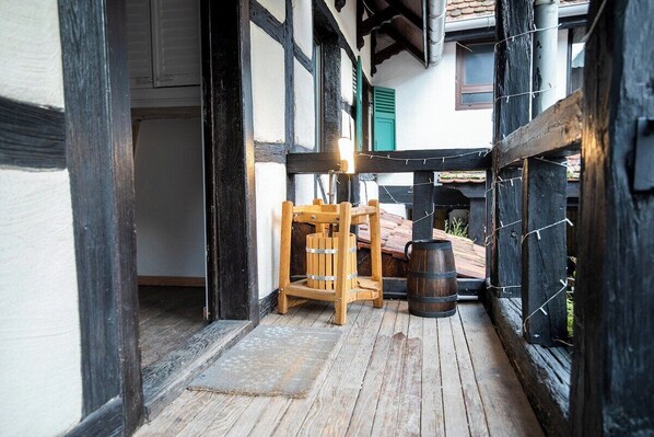 A wooden deck with a wooden bench and a barrel.