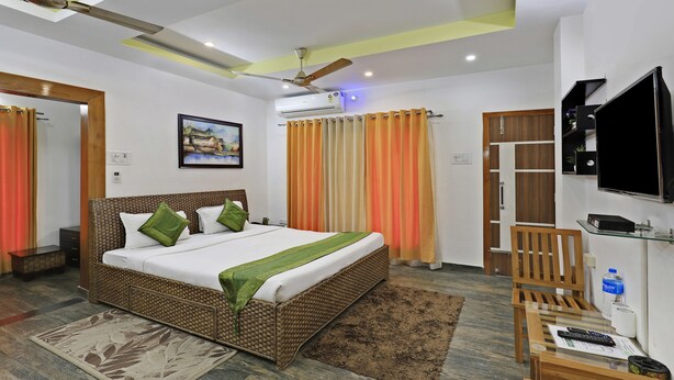 A hotel room with a bed, a television, a desk, and a bathroom. - Treebo Umal Homestay Ganeshguri (Guwahati)