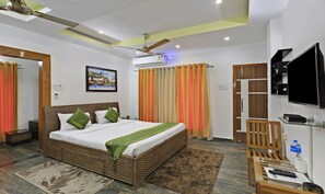 A hotel room with a bed, a television, a desk, and a bathroom.