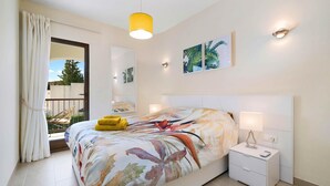 A bedroom with a bed, bedside table, and a window with curtains. - ASHANTI ZEN GARDEN DELUXE (ALTEA REGION) (La Nucia)