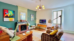 Una sala de estar con chimenea, televisor y sofá.
