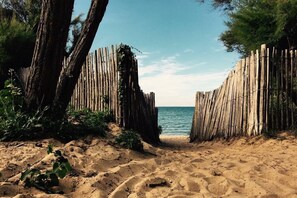 Una playa arenosa con una valla de madera que da al mar.