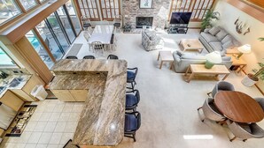 Een ruime open woonkamer met een keuken, eethoek en zithoek.