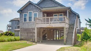 Ein zweistöckiges Haus mit einem Balkon, einer überdachten Eingangspforte und einer gut sichtbaren Hausnummer.