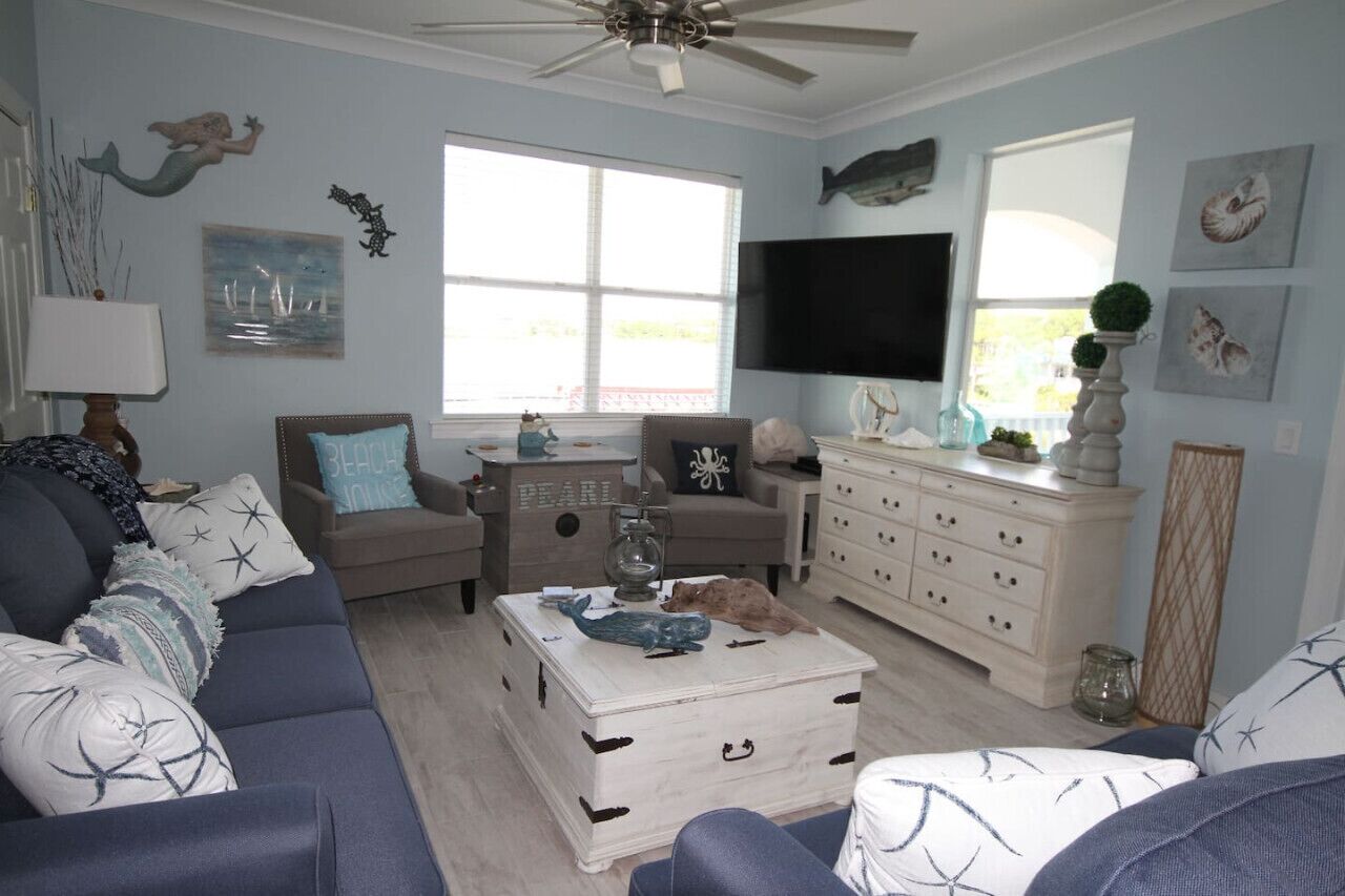 A living room with a sofa, a coffee table, a TV, and decorative items.