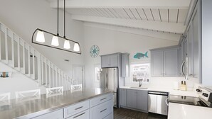 Een moderne keuken met witte kastjes, roestvrijstalen apparatuur en een houten vloer.