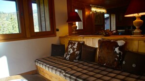 A cozy cabin interior with a wooden bench, plaid cushions, and a wooden table. - Superb chalet in Megève, 5CH, 4 bathrooms, close to center and ski lifts (Megève)