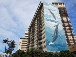 Un edificio alto con un grande murale raffigurante una balena sulla parete laterale.