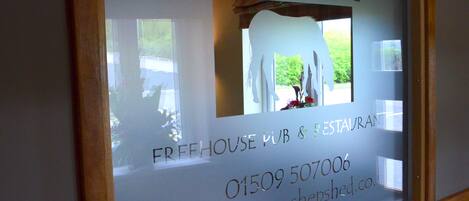 A window display for "The Horse" pub and restaurant with a contact number and website.