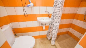 A bathroom with a white toilet, a sink, and a shower curtain with text. - Smart Apartment Kulisha 29a (Lviv)