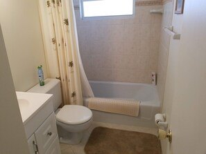A bathroom with a toilet, sink, and bathtub. - The entrance on Siesta Key (Siesta Key)