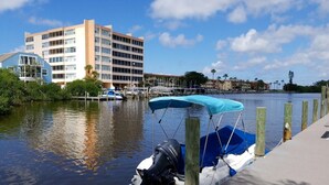 A marina with a docked boat, a wooden pier, and a multi-story building in the background. - The entrance on Siesta Key (Siesta Key)