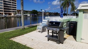 A waterfront patio with a grill, chairs, and a view of the marina. - The entrance on Siesta Key (Siesta Key)