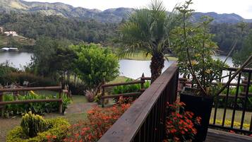 A wooden deck with a view of a lake and mountains.