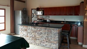 Una cocina con una isla de piedra, electrodomésticos de acero inoxidable y armarios de madera.