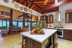 A spacious kitchen with a central island, wooden cabinets, and a stone backsplash.