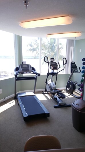Ein Fitnessstudio mit Laufbändern, Crosstrainern und Ergometer.