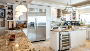 A modern kitchen with stainless steel appliances, granite countertops, and white cabinetry. - Luxury Home King Beds Ocean View 5 Min To Sandbar, Best Keys Experience! (Tavernier)