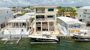 A waterfront property with multiple buildings, a dock with boats, and a clear view of the water. - Luxury Home King Beds Ocean View 5 Min To Sandbar, Best Keys Experience! (Tavernier)