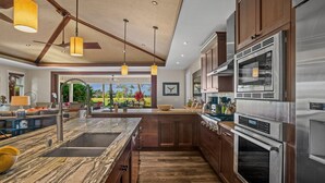Una cucina moderna con una grande isola, elettrodomestici in acciaio inossidabile e mobili in legno.